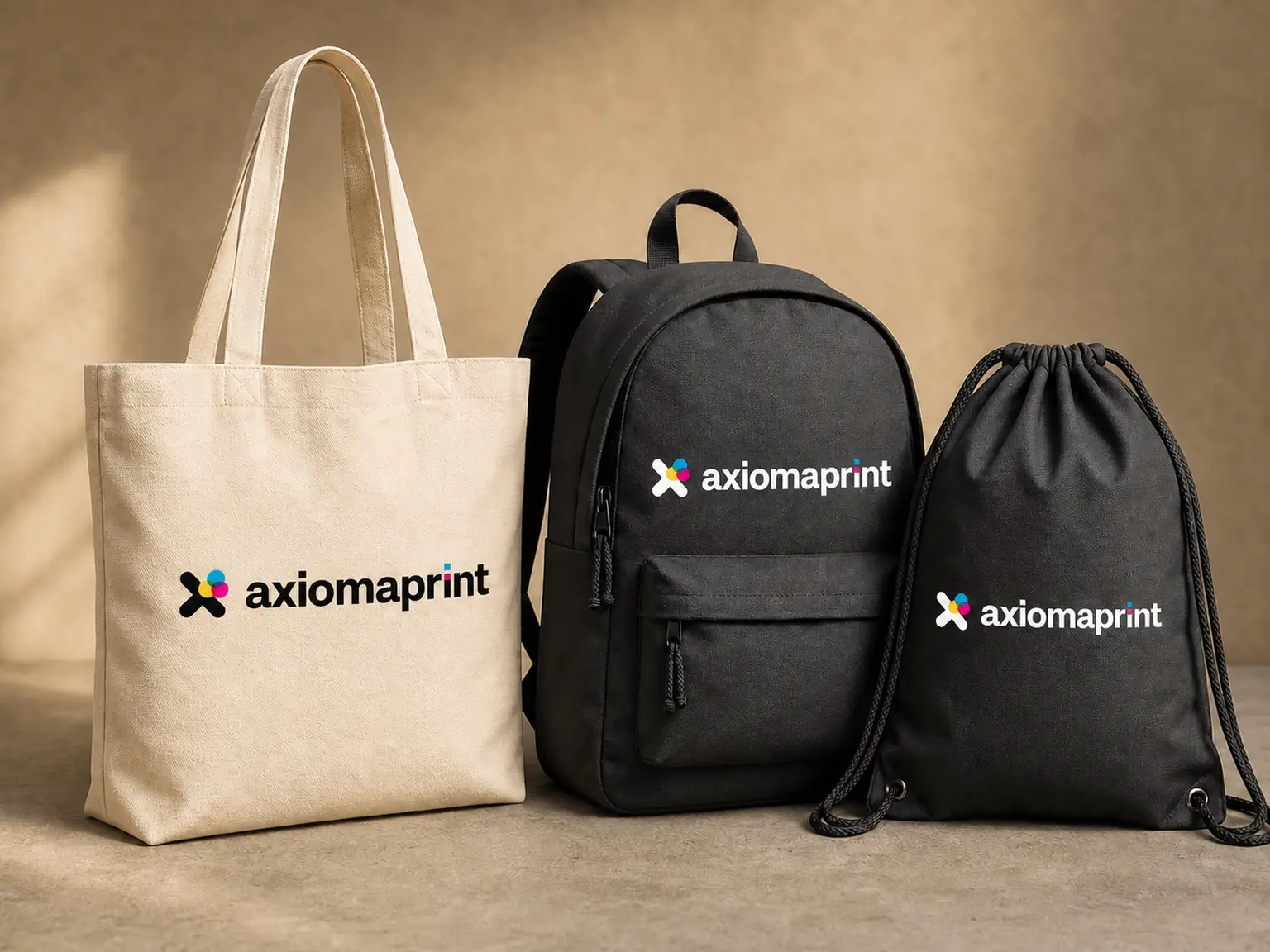 Bolsa de algodón cruda, mochila negra y mochila de cuerdas, las tres con el logotipo en el frontal
