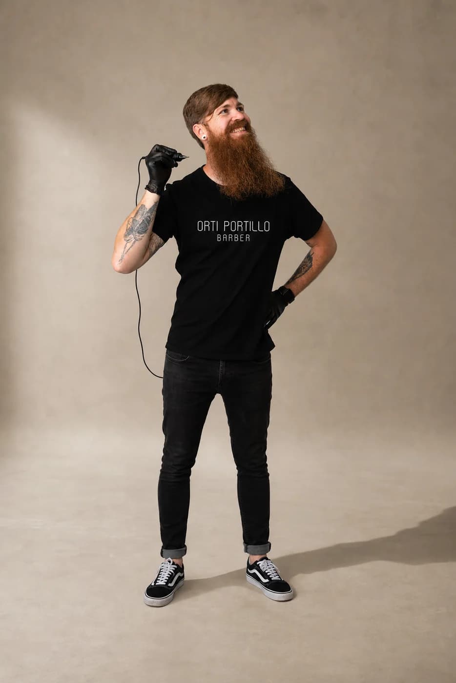 Barbero con la camiseta negra de su establecimiento