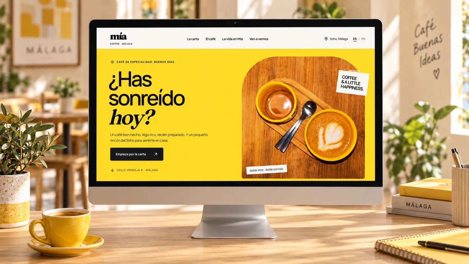 Presentación de la web de Mía Coffee en un monitor, en un entorno de cafetería